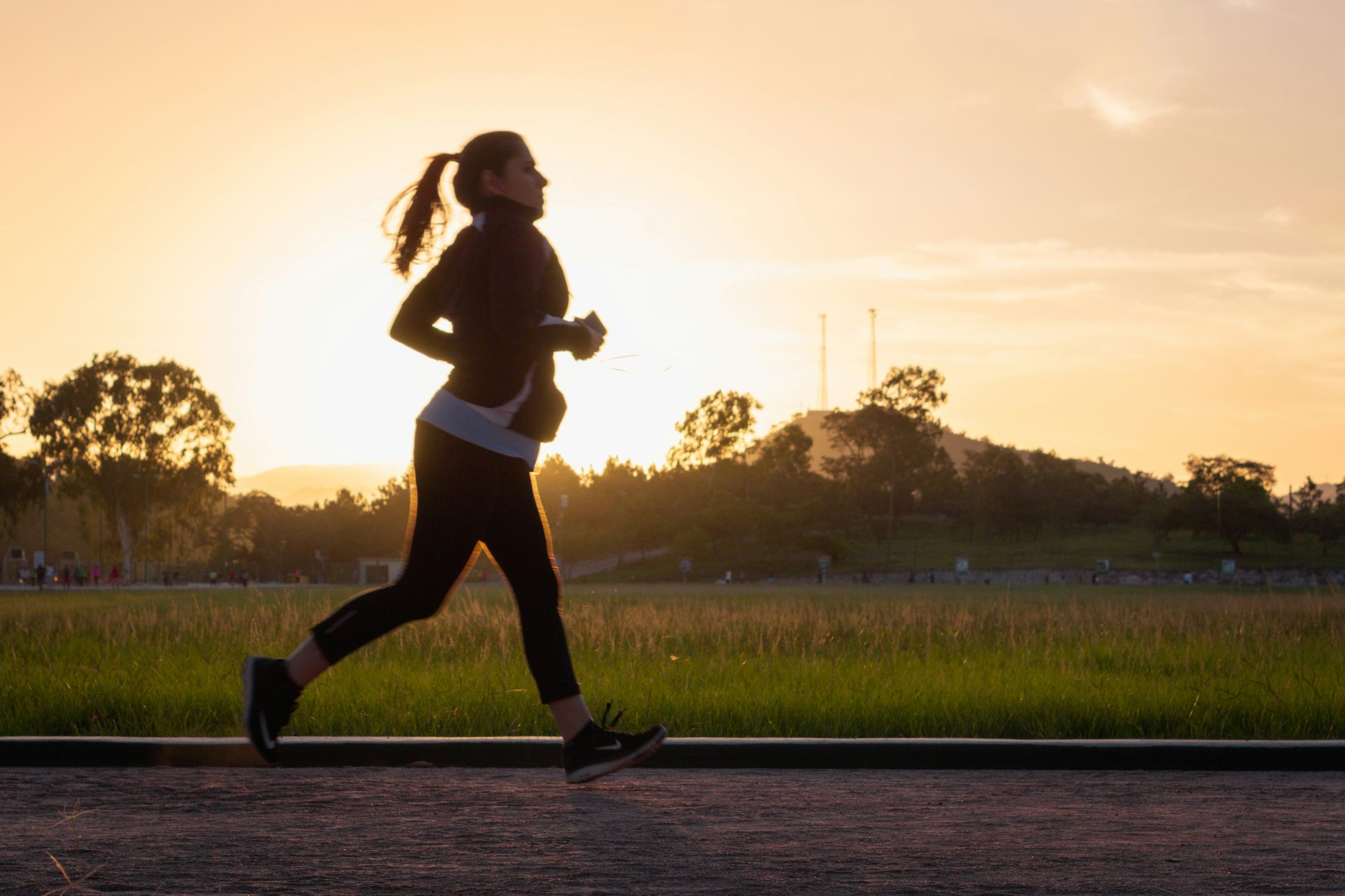 Woman running outdoors as she returns to exercise after having a baby